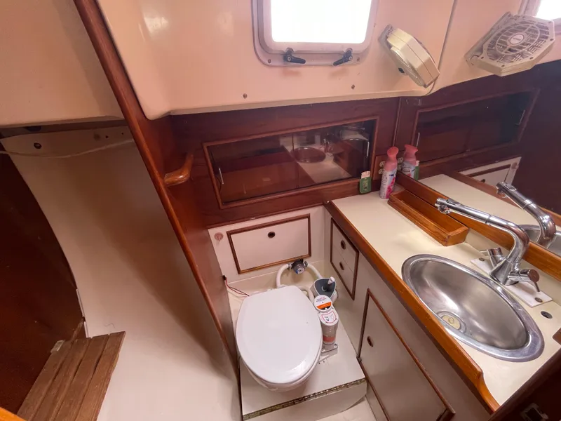 Slide: The Image of 1987 Nonsuch 30 Ultra yacht bathroom with sink, toilet, and storage cabinets. - 20