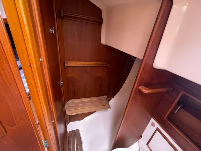 Slide: The Image of 1987 Nonsuch 30 Ultra sailboat interior with wooden cabinetry and seating area. - 21