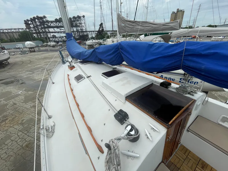 Slide: The Image of 1987 Nonsuch 30 Ultra sailboat with blue sail cover docked at marina. - 8