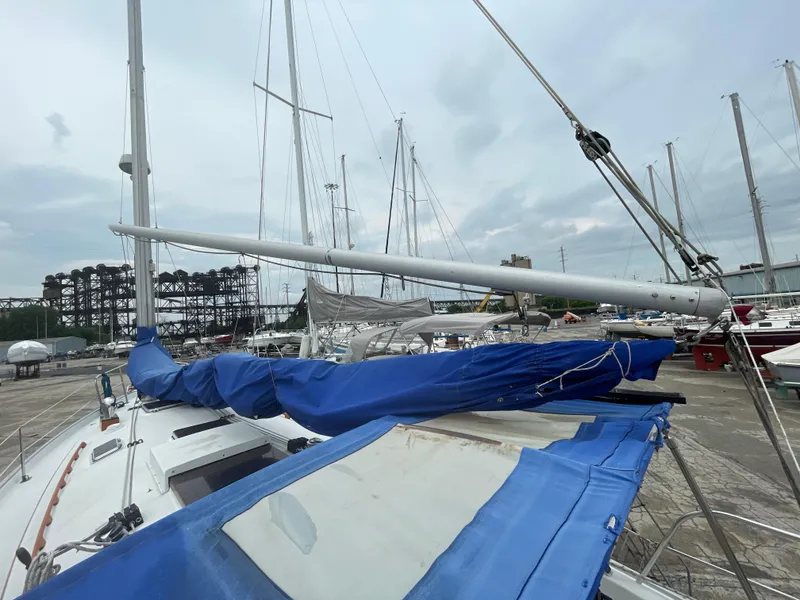 Slide: The Image of 1987 Nonsuch 30 Ultra sailboat with blue cover docked in a marina. - 9