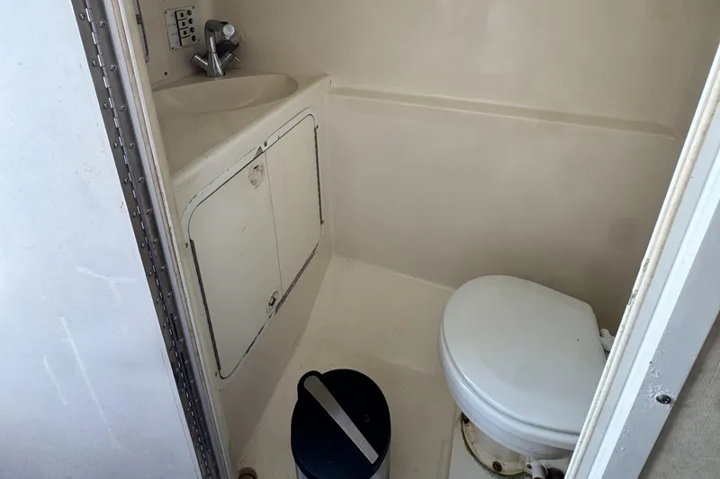 Slide: The Image of Compact bathroom in a 1999 Black Thunder 430 boat, featuring a toilet and sink. - 6