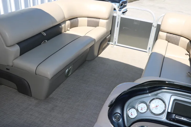 Slide: The Image of 2021 Sun Tracker Party Barge 20 DLX interior with beige seating and control panel. - 19