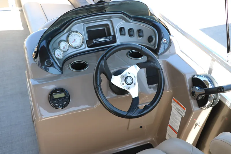 Slide: The Image of 2021 Sun Tracker Party Barge 20 DLX steering console with gauges and controls. - 21