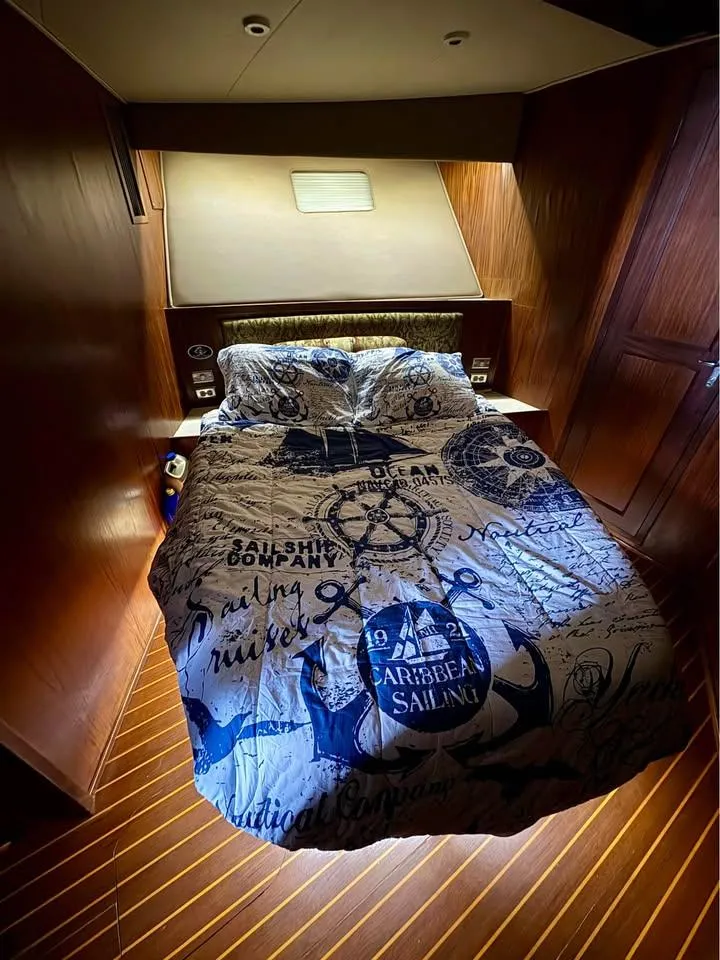 Slide: The Image of Luxurious cabin interior of 1983 Hatteras 46 Convertible yacht with nautical-themed bedding. - 10