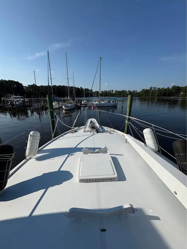Slide: The Image of Bow view of 1983 Hatteras 46 Convertible yacht docked at marina. - 6