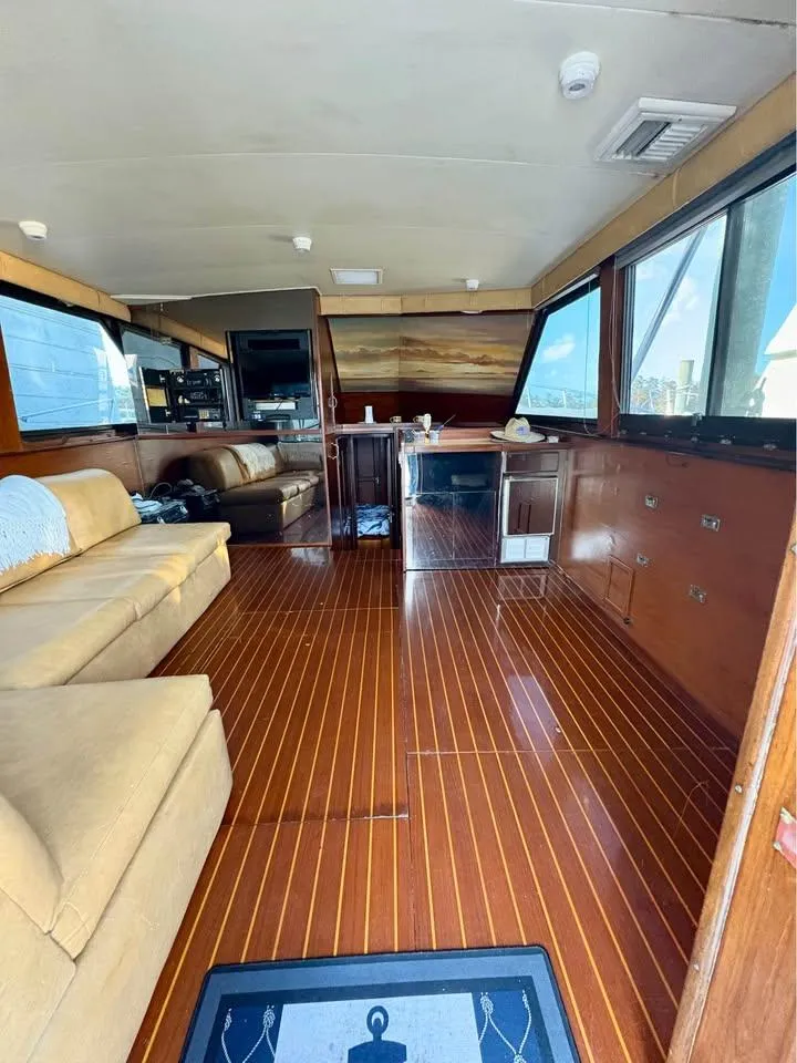 Slide: The Image of Interior of 1983 Hatteras 46 Convertible yacht with wooden flooring and beige seating. - 7
