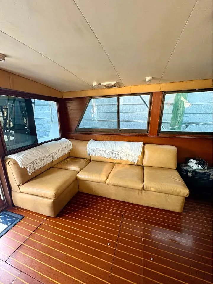 Slide: The Image of Interior of 1983 Hatteras 46 Convertible yacht with beige leather seating and wooden flooring. - 8