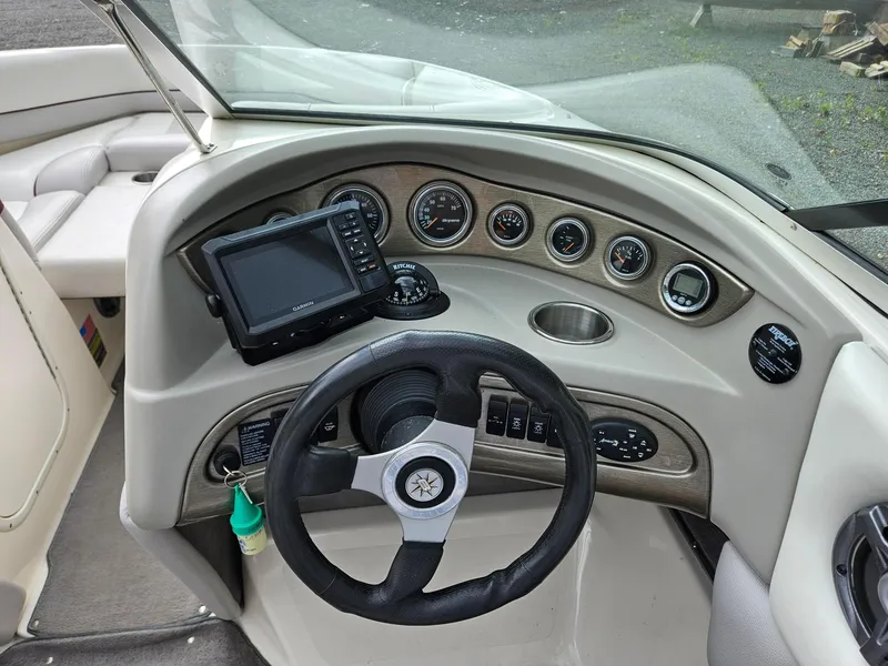 Slide: The Image of 2008 Bryant 233 boat dashboard with steering wheel, gauges, and Garmin GPS device. - 12