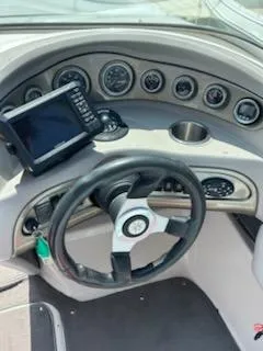 Slide: The Image of Dashboard of a 2008 Bryant 233 boat with steering wheel and gauges. - 13