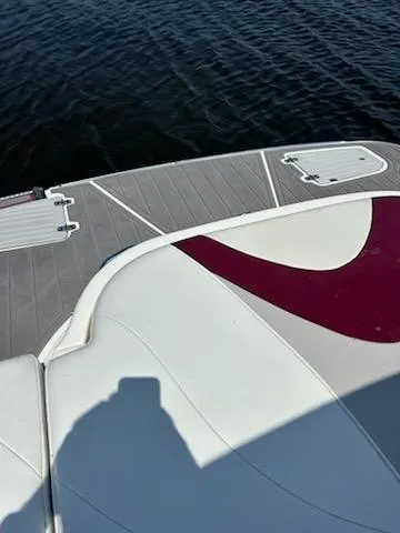 Slide: The Image of 2008 Bryant 233 boat deck with red and white seating, near calm water. - 18