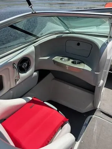 Slide: The Image of 2008 Bryant 233 boat interior with red life jacket, cup holders, and steering wheel. - 19