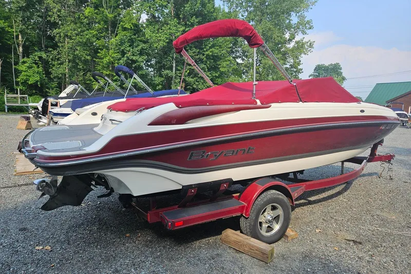 Slide: The Image of Red and white 2008 Bryant 233 boat on trailer, parked outdoors. - 2