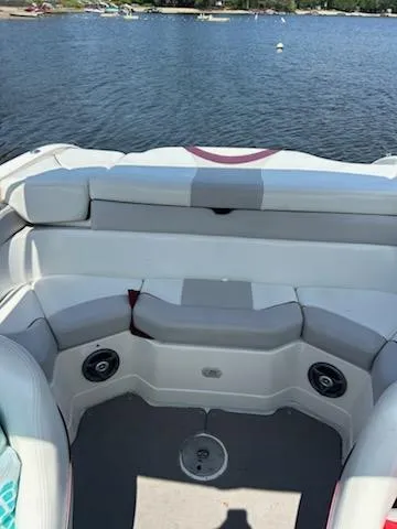 Slide: The Image of 2008 Bryant 233 boat interior with white seating, speakers, and lake view. - 20