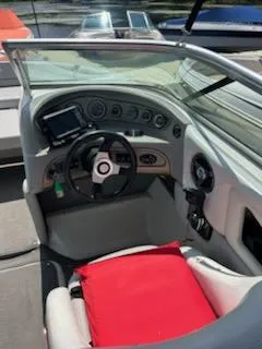 Slide: The Image of 2008 Bryant 233 boat cockpit with steering wheel and red cushion. - 23