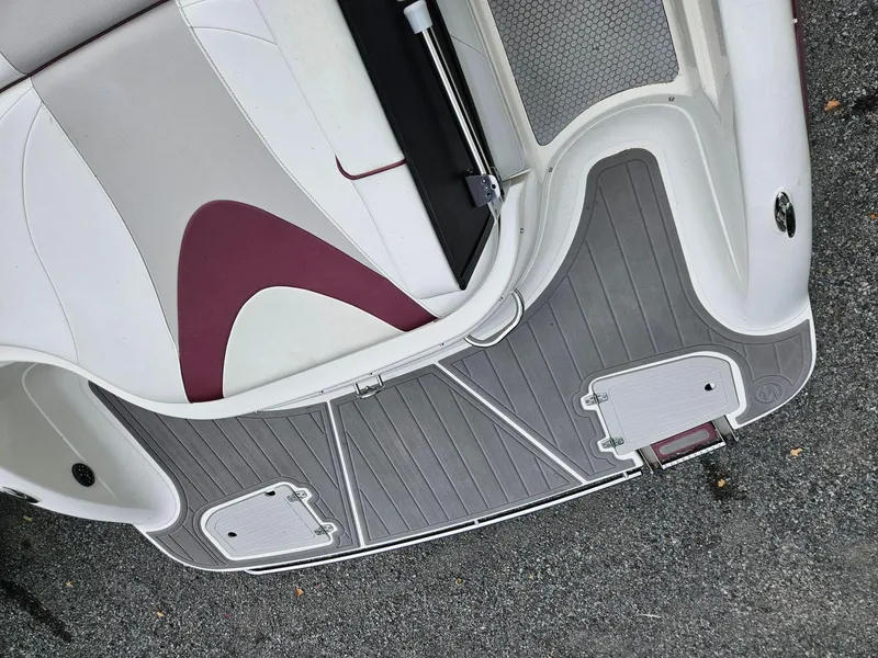 Slide: The Image of 2008 Bryant 233 boat interior with gray flooring and maroon-accented seating. - 25