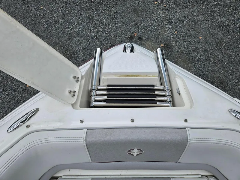 Slide: The Image of 2008 Bryant 233 boat ladder and seating area, featuring stainless steel and white upholstery. - 26