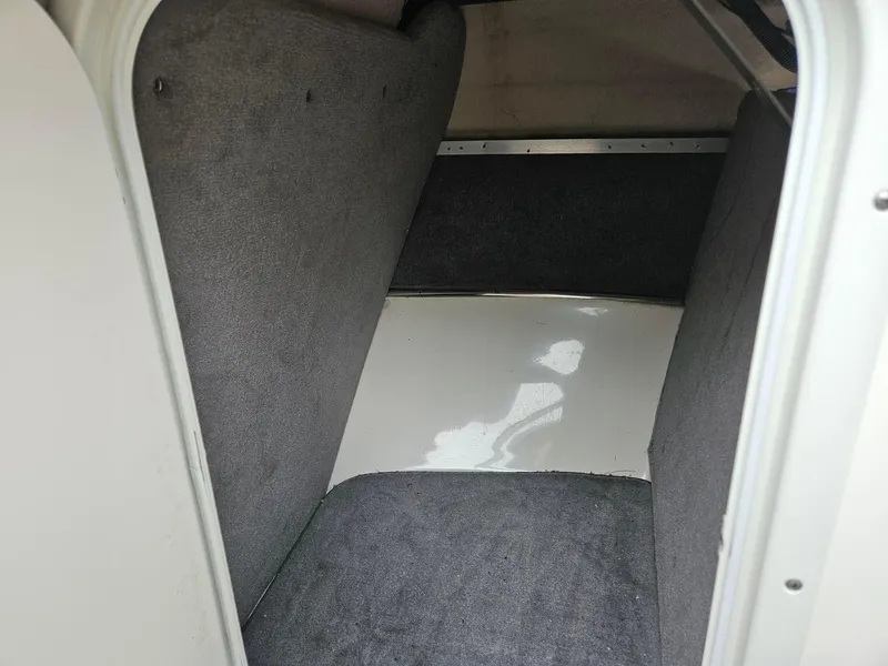 Slide: The Image of Interior cabin of a 2008 Bryant 233 boat, featuring carpeted walls and floor. - 31