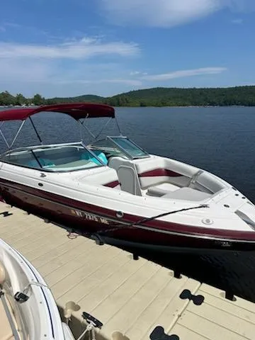 Slide: The Image of 2008 Bryant 233 boat docked on a sunny lake with a red canopy. - 4