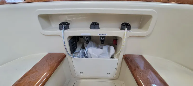 Slide: The Image of 2023 C.W. Hood 32 Daysailer cockpit storage with wooden accents and control panel. - 14