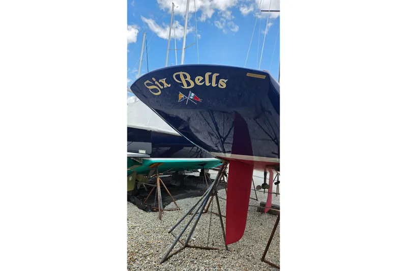 Slide: The Image of C.W. Hood 32 Daysailer 2023, named "Six Bells," displayed on stands under a blue sky. - 5