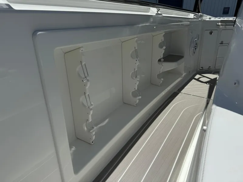 Slide: The Image of 2025 Wellcraft 38 T-Top boat interior with rod holders and storage compartments. - 14