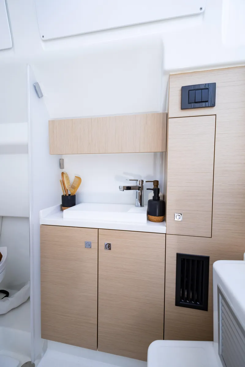 Slide: The Image of 2025 Wellcraft 38 T-Top boat interior with modern kitchenette and sleek cabinetry. - 17