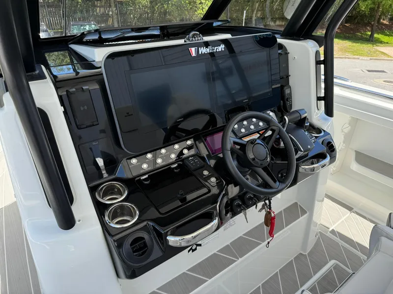 Slide: The Image of 2025 Wellcraft 38 T-Top boat dashboard with modern controls and steering wheel. - 18