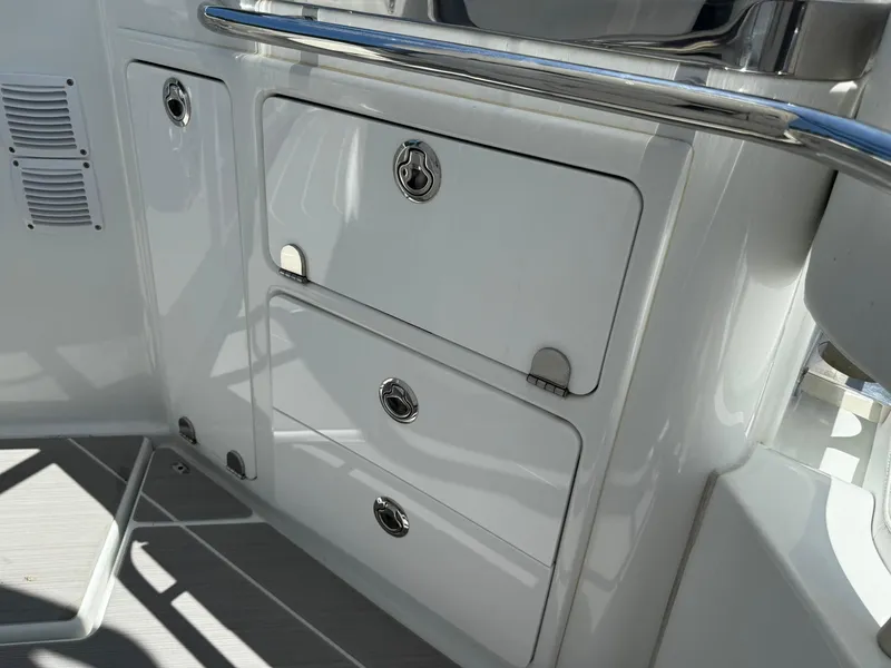 Slide: The Image of 2025 Wellcraft 38 T-Top boat storage compartments with sleek white finish and stainless steel handles. - 26