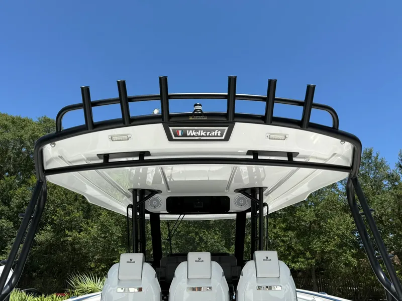 Slide: The Image of 2025 Wellcraft 38 T-Top boat with sleek design against clear blue sky. - 39