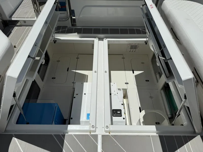 Slide: The Image of 2025 Wellcraft 38 T-Top boat storage compartment with open hatches and visible equipment. - 43