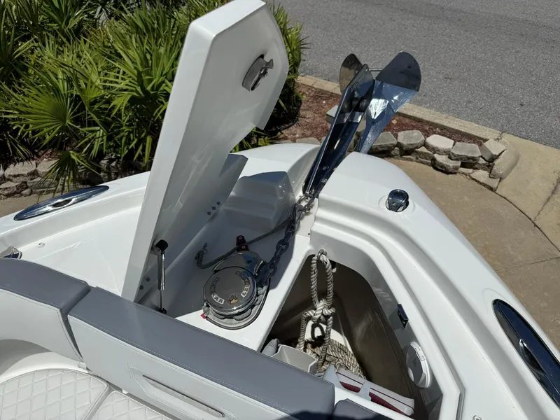 Slide: The Image of 2025 Wellcraft 38 T-Top boat anchor compartment with open hatch and visible anchor chain. - 8