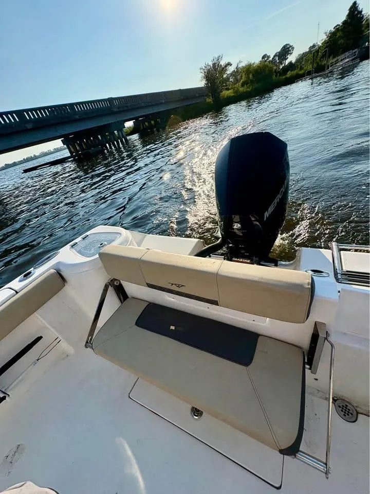 Slide: The Image of 2019 Tidewater 220 LXF boat with Mercury engine near a bridge on a sunny day. - 11