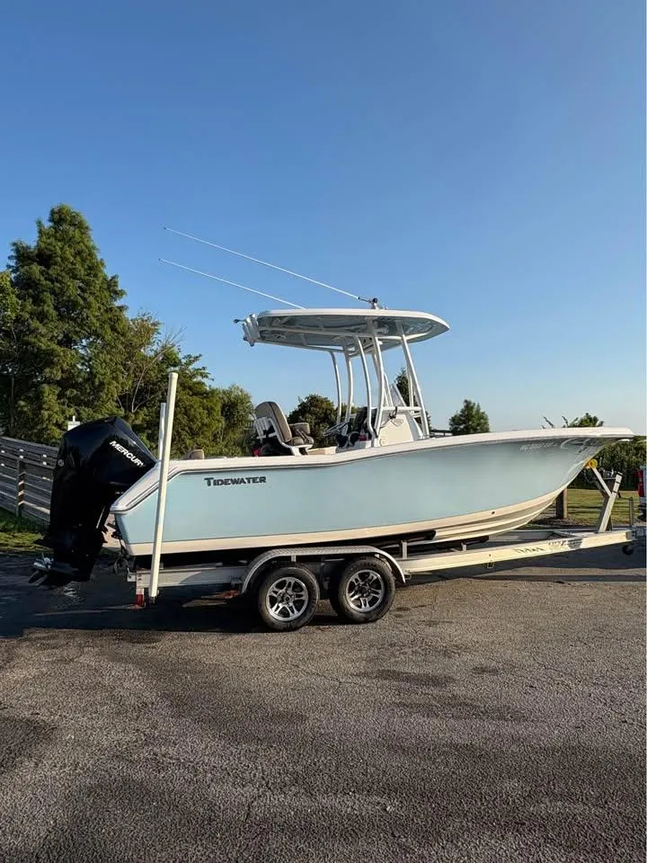 Slide: The Image of 2019 Tidewater 220 LXF boat on trailer, parked outdoors under clear sky. - 4