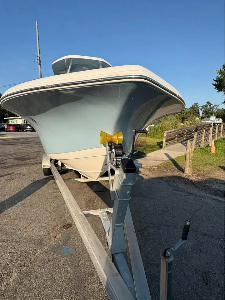 Slide: The Image of 2019 Tidewater 220 LXF boat on trailer, parked outdoors under clear blue sky. - 5