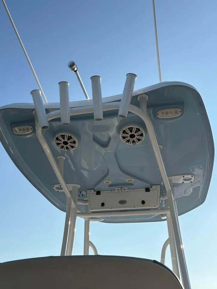 Slide: The Image of Tidewater 220 LXF 2019 boat T-top with rod holders and speakers against clear sky. - 9