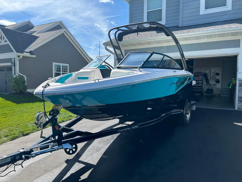 Slide: The Image of 2021 Regal 1900 ES Bowrider boat on trailer in driveway, sunny day. - 1