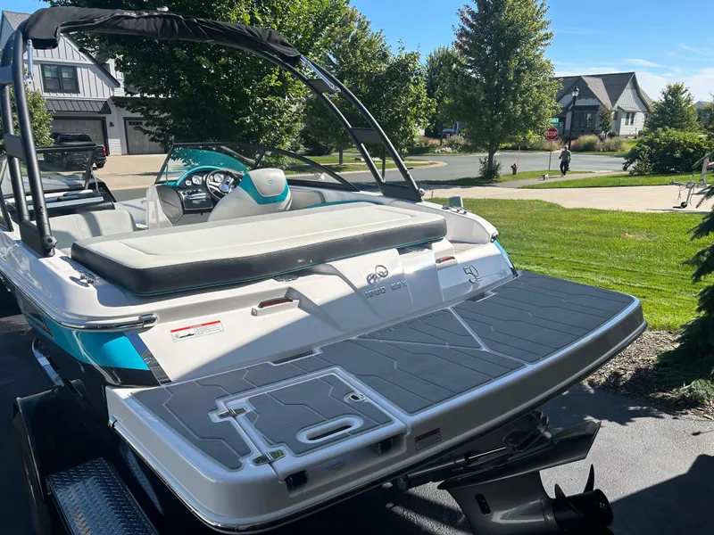 Slide: The Image of 2021 Regal 1900 ES Bowrider boat parked in a suburban driveway, showcasing sleek design. - 4