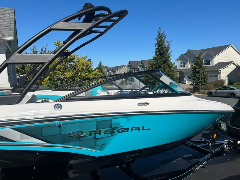 Slide: The Image of 2021 Regal 1900 ES Bowrider boat in driveway, vibrant blue and white design. - 5