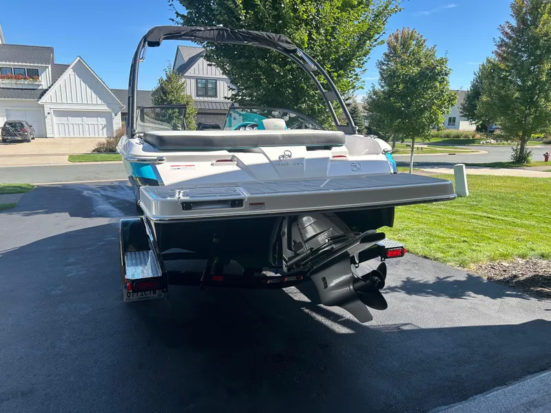 Slide: The Image of 2021 Regal 1900 ES Bowrider boat on trailer in suburban driveway. - 6