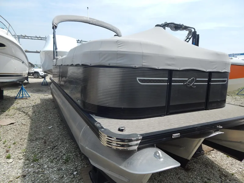 Slide: The Image of 2024 Qwest Splash Pad 822 pontoon boat with cover, parked on gravel. - 11