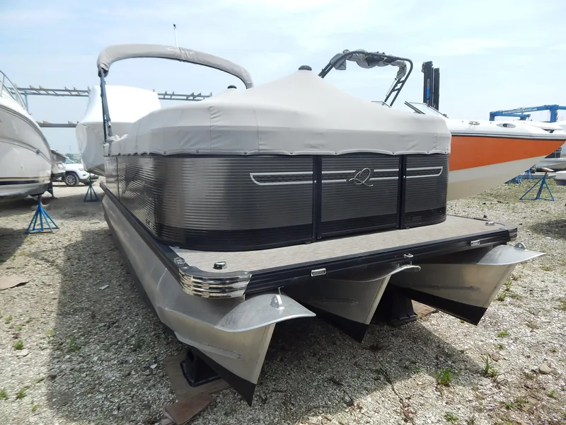 Slide: The Image of 2024 Qwest Splash Pad 822 pontoon boat with cover, parked on gravel. - 14