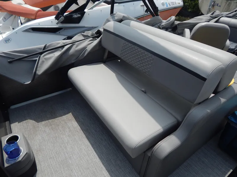 Slide: The Image of Gray seating area on 2024 Qwest Splash Pad 822 boat, featuring cup holder and textured upholstery. - 16