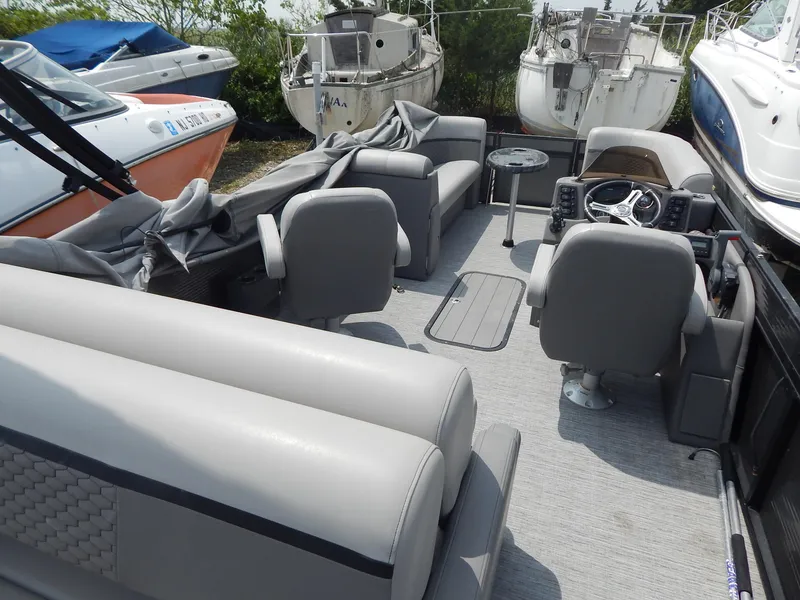 Slide: The Image of 2024 Qwest Splash Pad 822 pontoon boat interior with gray seating and steering console. - 18