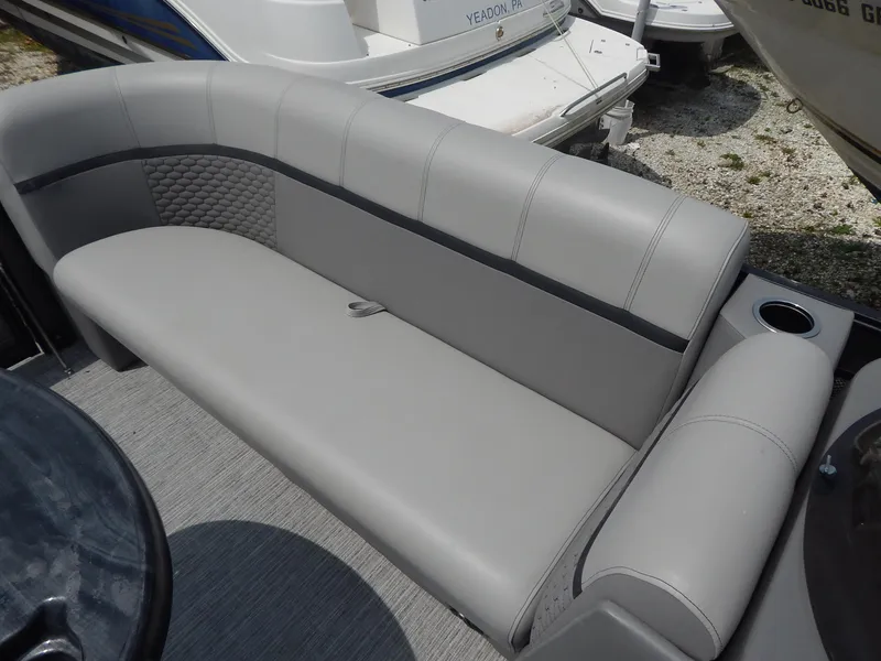 Slide: The Image of 2024 Qwest Splash Pad 822 boat interior with gray seating and cup holder. - 22