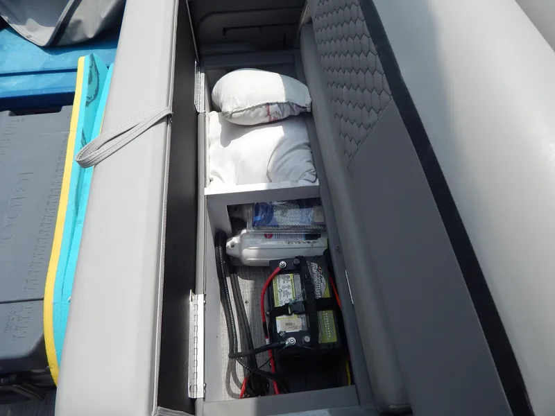 Slide: The Image of Storage compartment in 2024 Qwest Splash Pad 822 boat, featuring battery and cushions. - 30