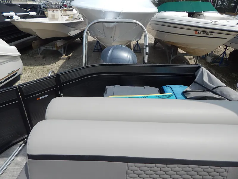 Slide: The Image of 2024 Qwest Splash Pad 822 pontoon boat interior with seating, docked among other boats. - 35