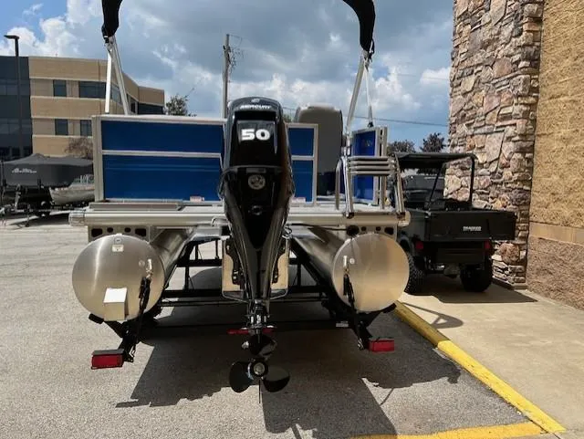 Slide: The Image of 2026 Sun Tracker Party Barge 16 DLX with 50 HP engine, parked outdoors. - 2