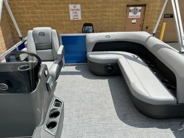Slide: The Image of 2026 Sun Tracker Party Barge 16 DLX interior with gray seating and steering console. - 3