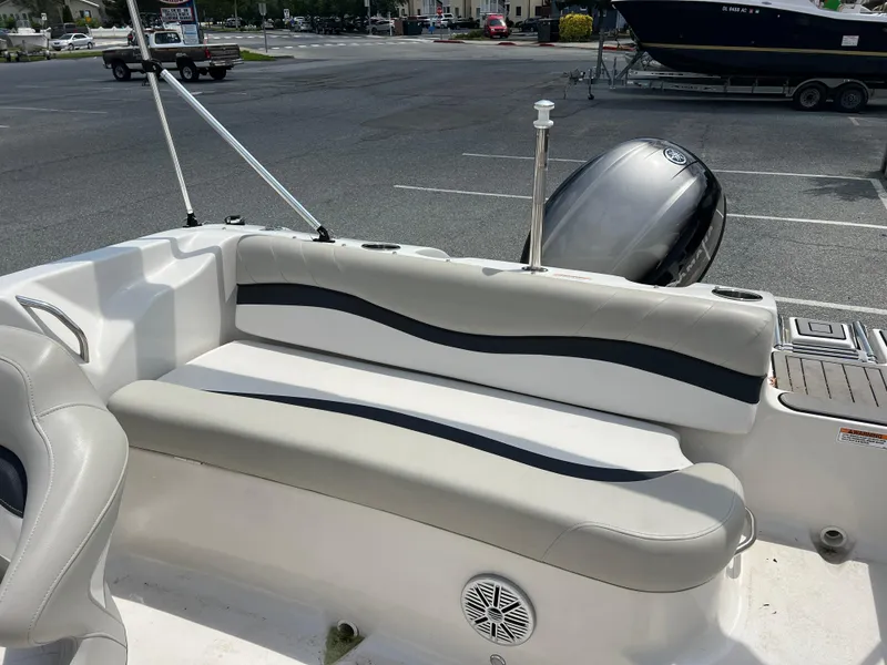 Slide: The Image of 2021 Starcraft Limited 1915 OB boat interior with seating and motor in a parking lot. - 19