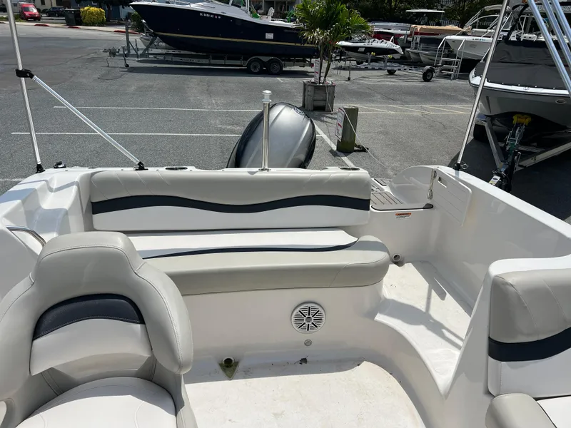 Slide: The Image of 2021 Starcraft Limited 1915 OB boat interior with seating and speaker, parked in a marina. - 20